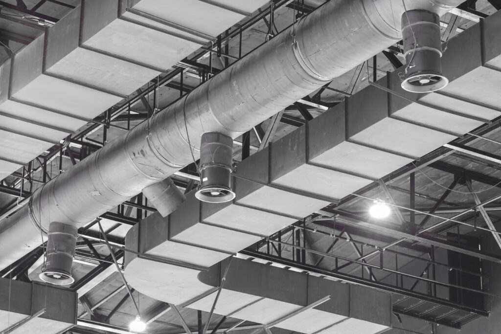 HVAC Duct Cleaning, Ventilation pipes in silver insulation material hanging from the ceiling inside new building.